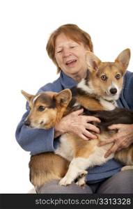 senior woman holding two active corgi puppies on her laps