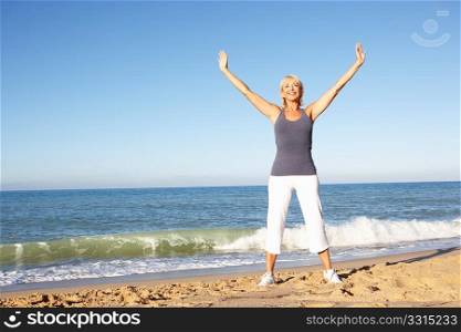 Senior Woman In Fitness Clothing Stretching On Beach