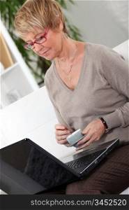 Senior woman in front of a laptop at home