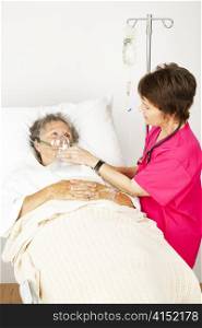 Senior woman in the hospital with lung disease, getting oxygen from a nurse.