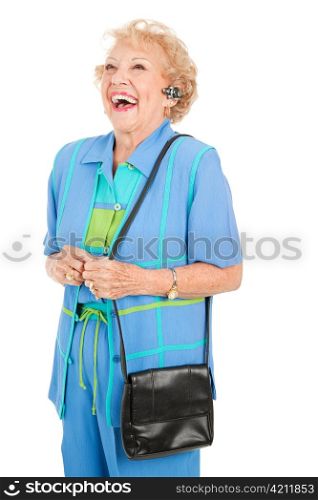 Senior woman laughing while taking on the hands free set for her cellphone. Isolated on white.