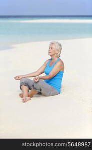 Senior Woman Meditating On Beautiful Beach