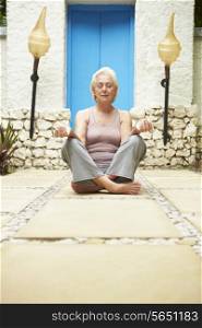 Senior Woman Meditating Outdoors At Health Spa