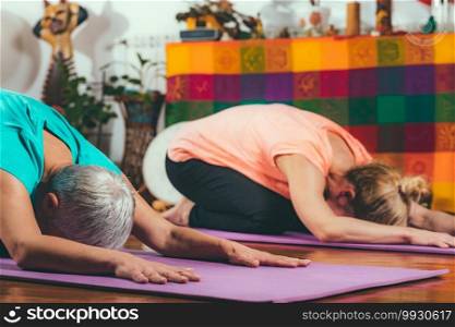  Senior woman on private yoga class with personal trainer.  