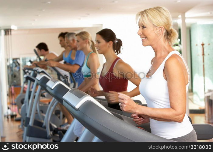 Senior Woman On Running Machine In Gym