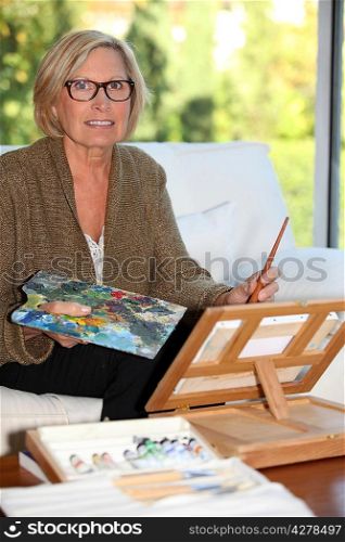 senior woman painting at home