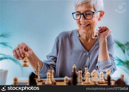 Senior woman playing chess. Cognitive rehabilitation activity.. Cognitive Rehabilitation Activity. Senior Woman Playing Chess.
