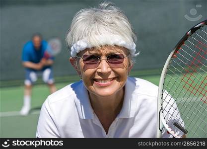 Senior woman playing tennis, portrait