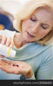 Senior Woman Pouring Pills Out Of Bottle