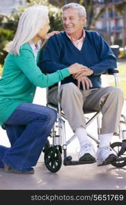 Senior Woman Pushing Husband In Wheelchair