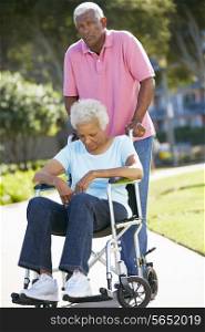 Senior Woman Pushing Unhappy Husband In Wheelchair
