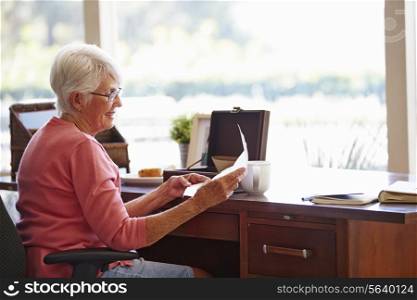 Senior Woman Putting Letter Into Keepsake Box