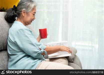 Senior woman reading book, enjoy and relax, stay alone at home. Enjoying Retirement And Time On Isolation, grandparents care, social distance celebration at home, elderly favorite pastime