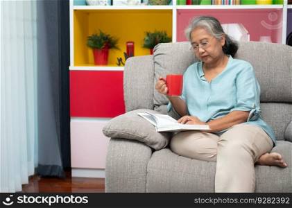 Senior woman reading book, enjoy and relax, stay alone at home. Enjoying Retirement And Time On Isolation, grandparents care, social distance celebration at home, elderly favorite pastime