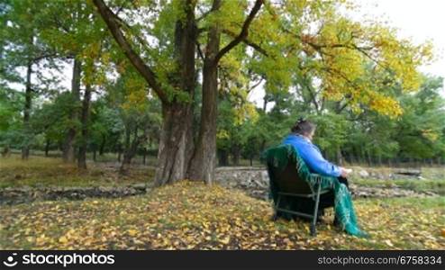 Senior Woman Reading Book in Autumn Park. lockdown, Wide Angle