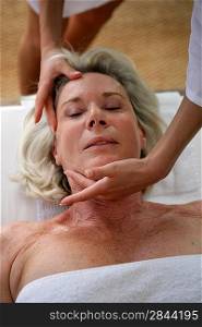 Senior woman receiving head massage
