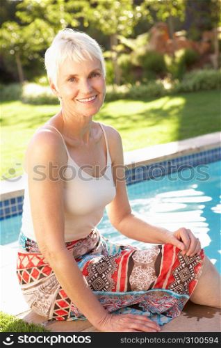 Senior Woman Relaxing By Pool In Garden