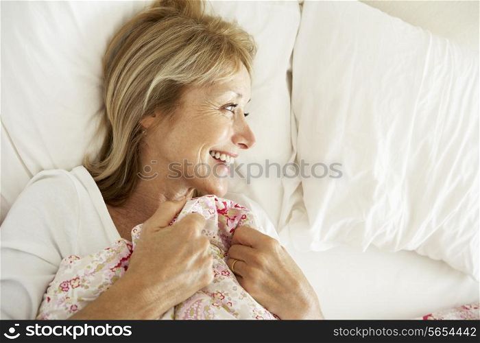 Senior Woman Relaxing In Bed