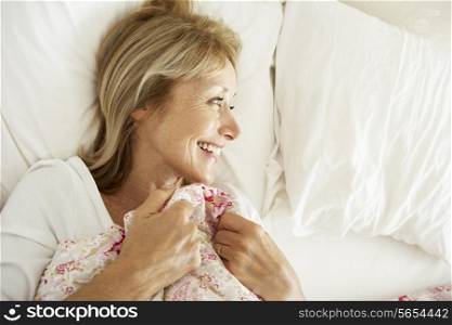 Senior Woman Relaxing In Bed