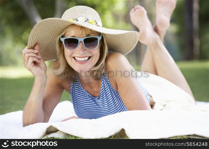 Senior Woman Relaxing In Summer Garden