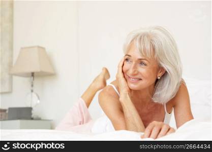 Senior Woman Relaxing On Bed