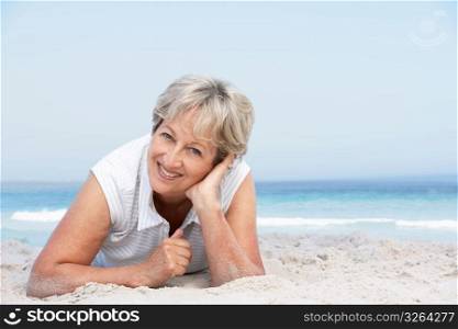 Senior Woman Relaxing On Sandy Beach