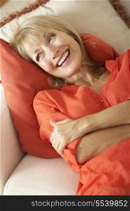 Senior Woman Relaxing On Sofa At Home