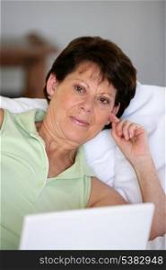 senior woman relaxing on the couch with her laptop