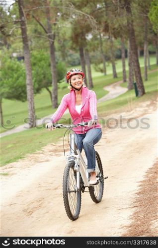 Senior woman riding bicycle in park