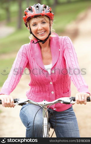 Senior woman riding bicycle in park