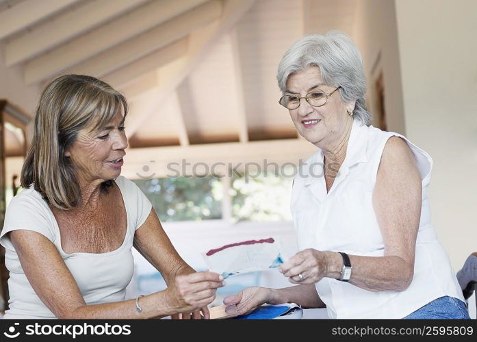 Senior woman showing a photograph to another senior woman