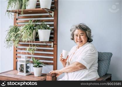 Senior woman sitting and drinking coffee or milk