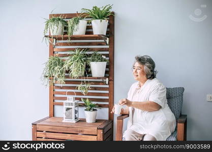 Senior woman sitting and drinking coffee or milk