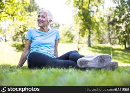Senior woman sitting and resing after workout in park