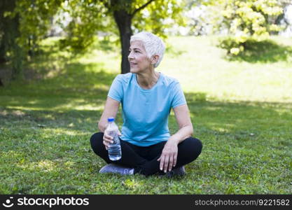 Senior woman sitting and resing after workout in park