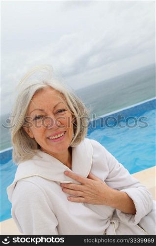 Senior woman sitting by pool