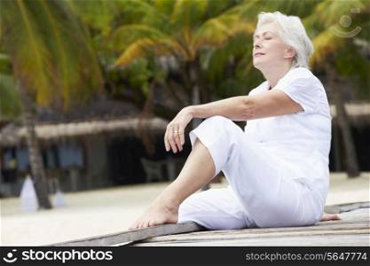 Senior Woman Sitting On Wooden Jetty
