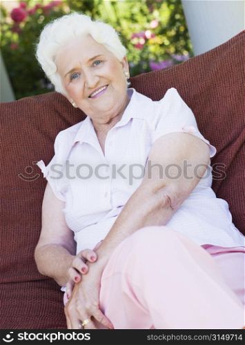Senior woman sitting outdoors on a chair