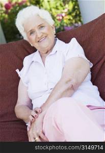 Senior woman sitting outdoors on a chair