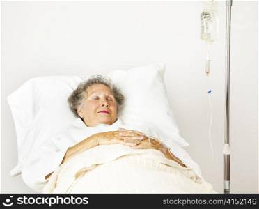 Senior woman sleeping in a hospital bed.
