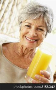 Senior Woman Smiling At Camera And Drinking Orange Juice
