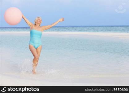 Senior Woman Splashing In Beautiful Sea Holding Balloon