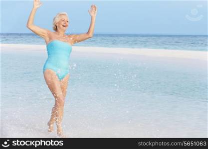 Senior Woman Splashing In Beautiful Tropical Sea