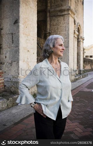 Senior woman standing in front of a building and smiling, Santo Domingo, Dominican Republic