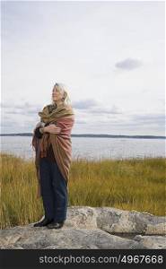 Senior woman standing near a lake