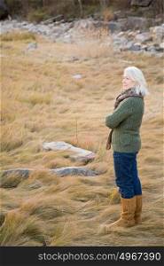 Senior woman standing on long grass