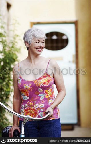 Senior woman standing with a bicycle