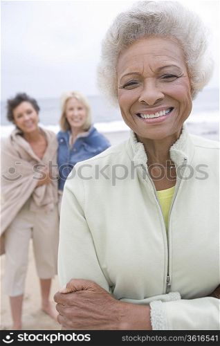 Senior woman stands in fleece jacket on beach