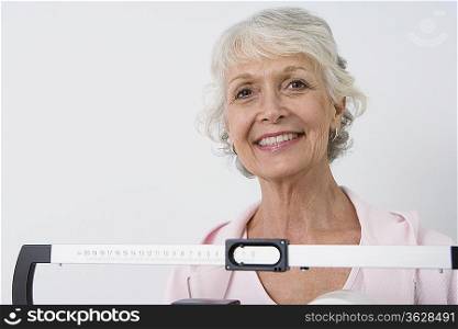Senior woman stands on hospital scales