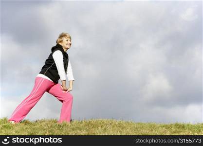 Senior Woman Stretching In Park